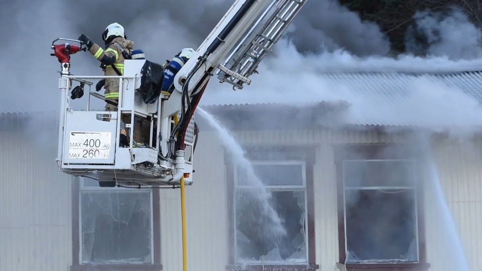 Vigili del fuoco con l'autoscala spengono un incendio